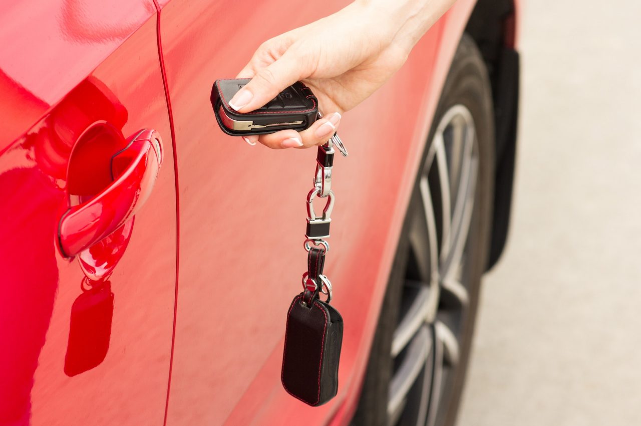 female-hand-opens-the-door-of-a-red-car.jpg
